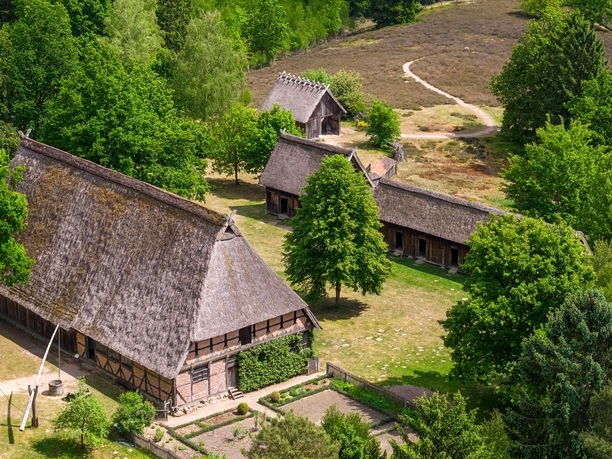 hauptbild-museumsdorf-hoesseringen-fotocredits-thorsten-scherz-1920x1080px.jpg Luftaufnahme historischer Reetdach-Fachwerkhäuser im grünen Museumsdorf Hösseringen.