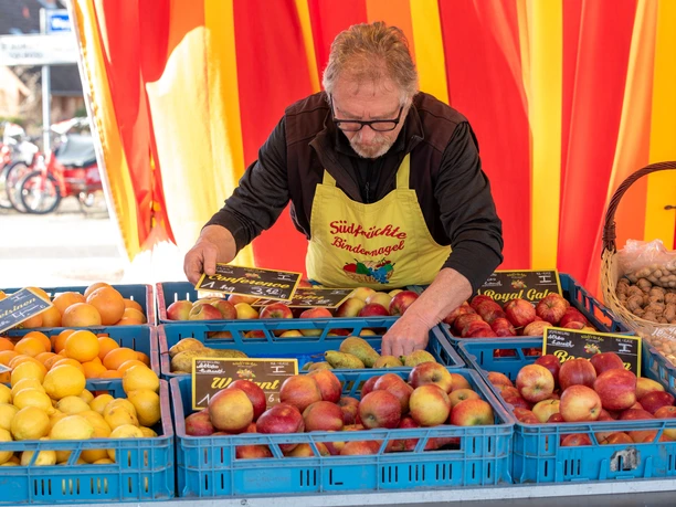 Adendorfer Wochenmarkt Obststand Verkopers bij een kraam met appels, citroenen en sinaasappels