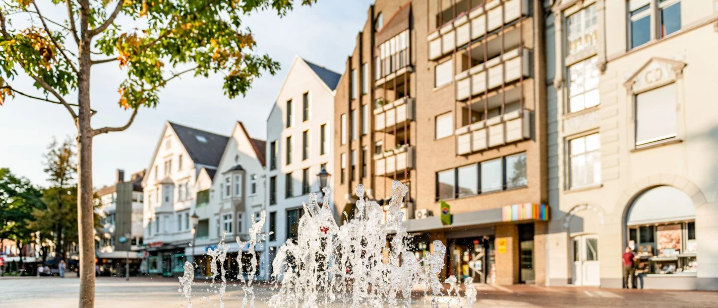 Innenstadt Gütersloh Springbrunnen auf dem Berliner Platz vor Häuserzeile in Güterslohs Innenstadt