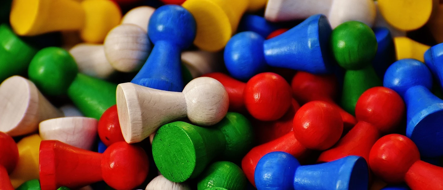 alexas_fotos-play-stone-1743628_1920.jpg Zahlreiche bunte Holzspielfiguren in Rot, Blau, Grün, Gelb und Naturholz liegen dicht beieinander.