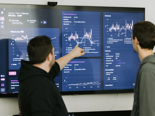 Research on AI and big data in the digital economy in Leipzig | Leipzig Convention Bureau Two researchers from the digital economy reviewing an AI analysis on a screen – presented by Leipzig Convention Bureau