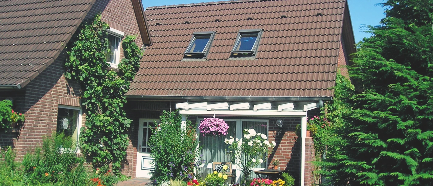 Ferienwohnung Neetzetal Aussenansicht Außenansicht eines Backsteinhauses mit gepflegtem Vorgarten, Blumen und einer kleinen Terrasse.