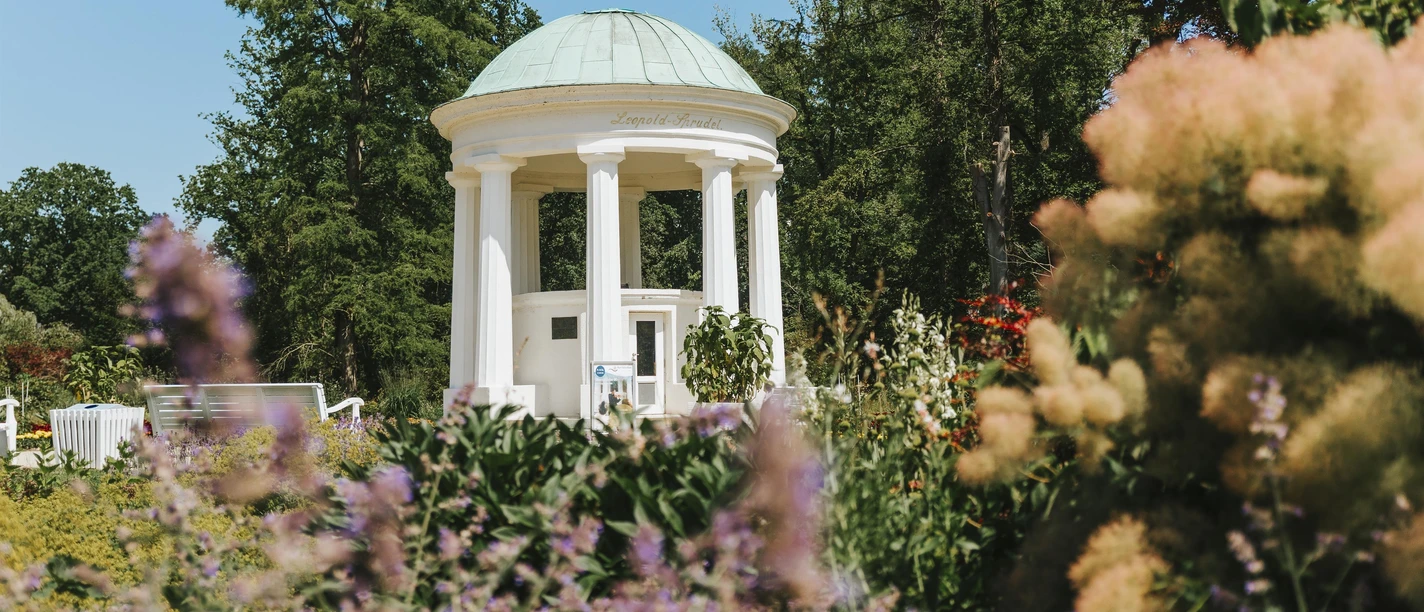 Leopoldsprudel-Pavillon im Kurpark Bad Salzuflen, umgeben von blühenden Beeten