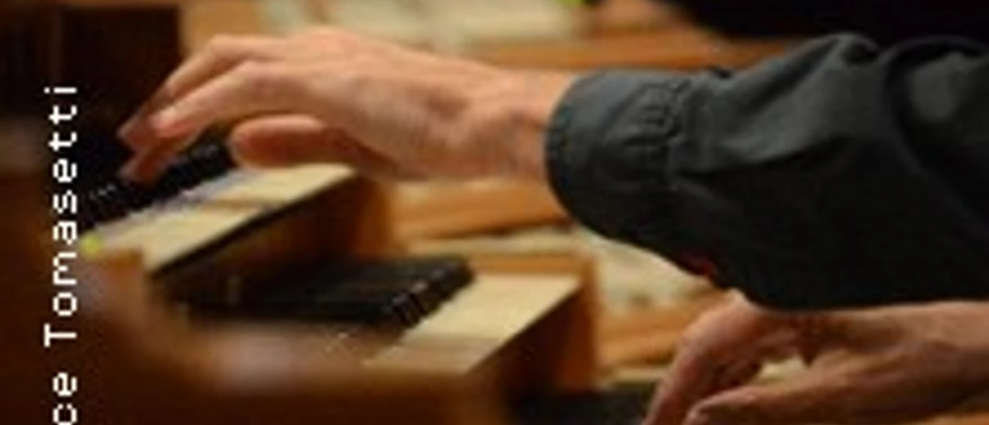 Hände spielen an einer Orgelkonsole mit mehreren Manualen.