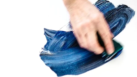 Tagträume_Maren Hoch (c) KuKuK.jpg Eine Hand malt mit Hilfe eines Schwammes mit blauer Farbe auf weißen Untergrund.