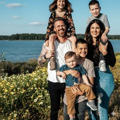 OfflineZeit-Familienzeit.png Eine lachende Familie mit vier Kindern steht vor gelben Blumen am Ufer des Steinhuder Meeres.
