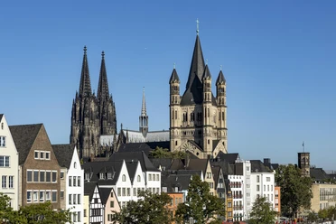 Old town of Cologne Colorful houses in Cologne's old town in front of the cathedral and St. Martin's Cathedral under a blue sky
