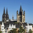 Old town of Cologne Colorful houses in Cologne's old town in front of the cathedral and St. Martin's Cathedral under a blue sky