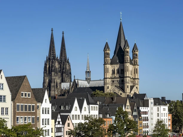 Old town of Cologne Colorful houses in Cologne's old town in front of the cathedral and St. Martin's Cathedral under a blue sky