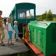 Moorbahn Ahlenmoor Familie auf einem Holzsteg entdeckt die grüne Moorbahn im sonnigen Ahlenmoor.