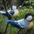 gefilzte Meisen - MoorIZ Zwei handgefilzte Blaumeisen sitzen auf feinen Zweigen in der grünen Natur.