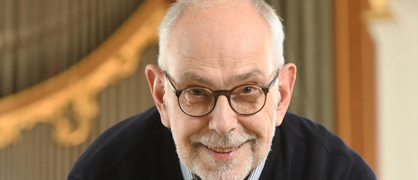 C. Schoener02_Copyright Michael Zapf.jpg Christoph Schoener lächelt entspannt und stützt sich auf den Spieltisch einer großen Kirchenorgel.