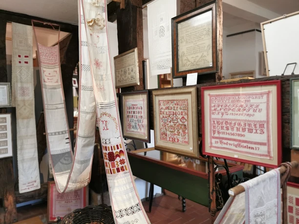 Exponate im Stickereimuseum Stickereien und gerahmte Handarbeiten in einem Museum. Traditionelle Textilkunst wird präsentiert.