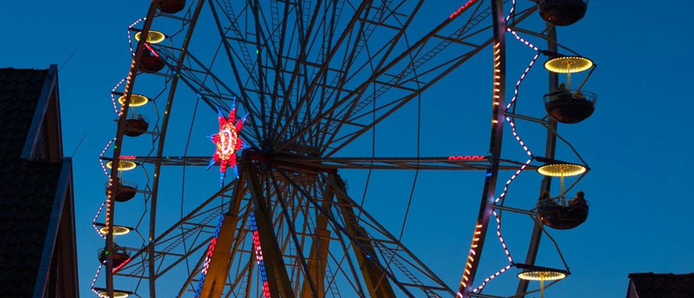 Lüttes Altstadtfest_2025 Das bunt beleuchtete Riesenrad des Altstadtfestes in Otterndorf vor blauem Nachthimmel.