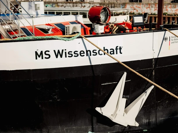 A floating science center Bow of the MS Wissenschaft with white anchor, ropes and technical equipment on deck.