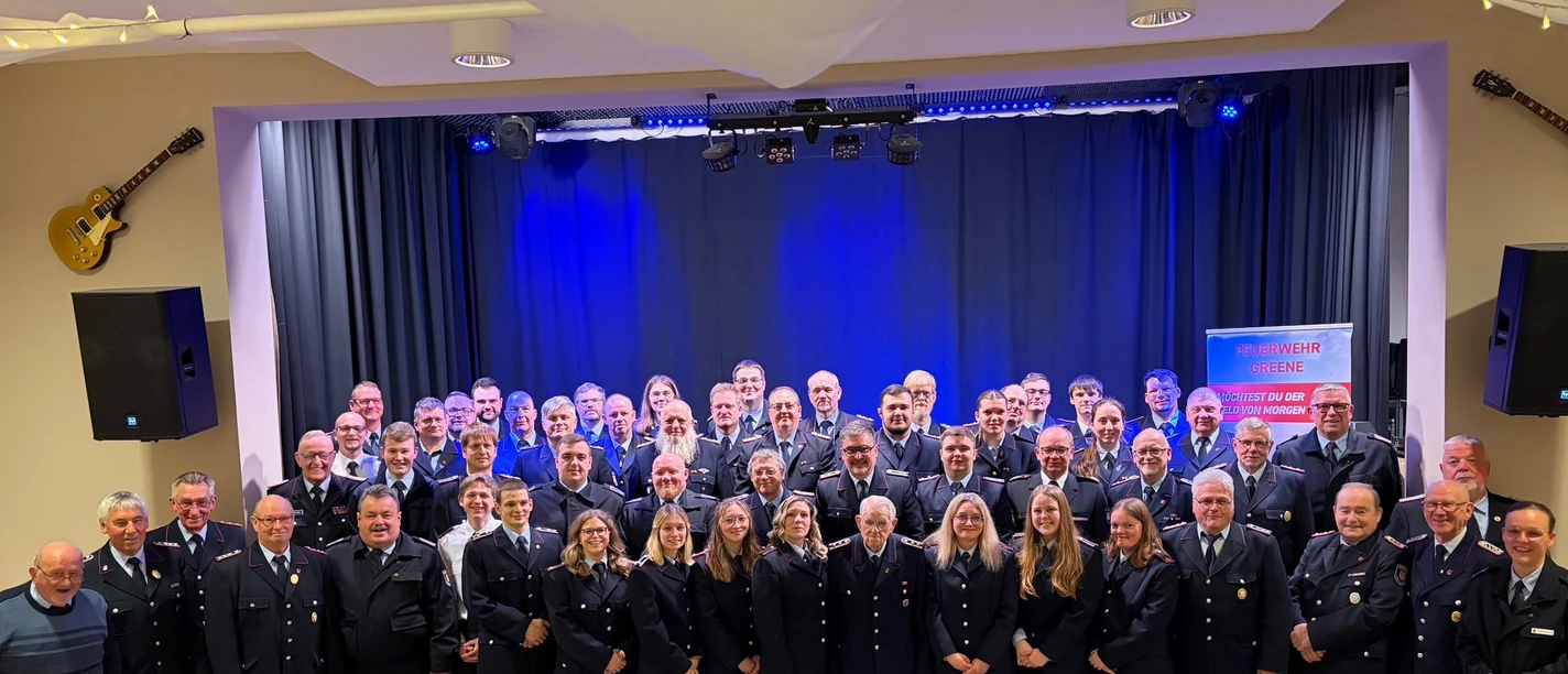 JHV 2026.JPEG Gruppenfoto der Feuerwehr Greene in Uniform auf einer Bühne vor blauem Vorhang.