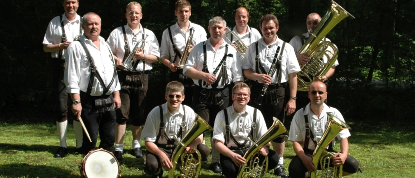 20241012_hallo_minden_frohsinn_und_gemutlichkeit_wehe_suelter.jpg Elf Musiker in Tracht stehen mit Blasinstrumenten und einer Trommel auf einer Wiese.