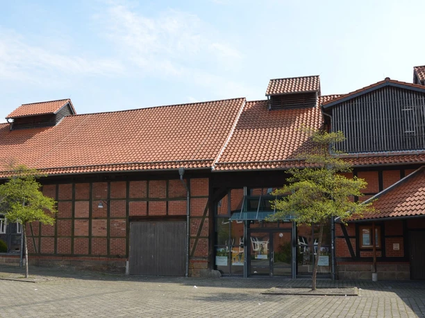 Kulturscheune_HD_16zu9.JPG Backstein-Fachwerkscheune mit rotem Ziegeldach, Glaseingang und Vorplatz.