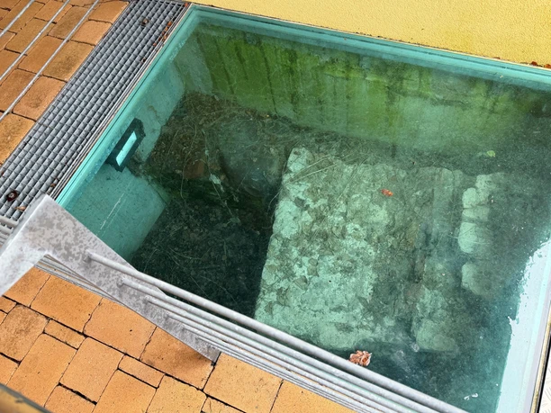 Historische Grundmauern der Burg Langwedel, sichtbar unter einer schützenden Glasplatte im Boden.