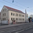 Erich-Zeigner-Haus Leipzig - Begegnungsorte in Leipzig Seitliche Ansicht der Front des Erich-Zeigner-Hauses in Leipzig in der Abenddämmerung mit der davorliegenden Straße und den Straßenbahnschienen