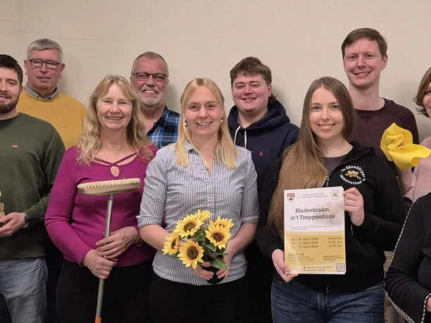 Theaterverein-Evendorf_Sluuderkraam in t Treppenhuus.jpg Zehn Personen der Theatergruppe Evendorf posieren mit Requisiten und einem Plakat.