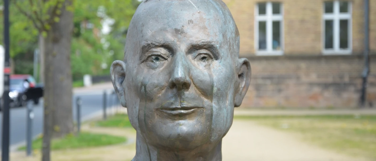 Franz Zobel_HD_16zu9.JPG Bronzene Büste von Franz Zobel im Freien vor unscharfen Bäumen und einem Haus.