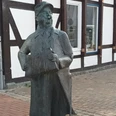 Seppchen Muthig_HD_16zu9.jpg Bronzestatue von Seppchen Muthig mit Akkordeon vor einem Fachwerkhaus in Salzgitter.