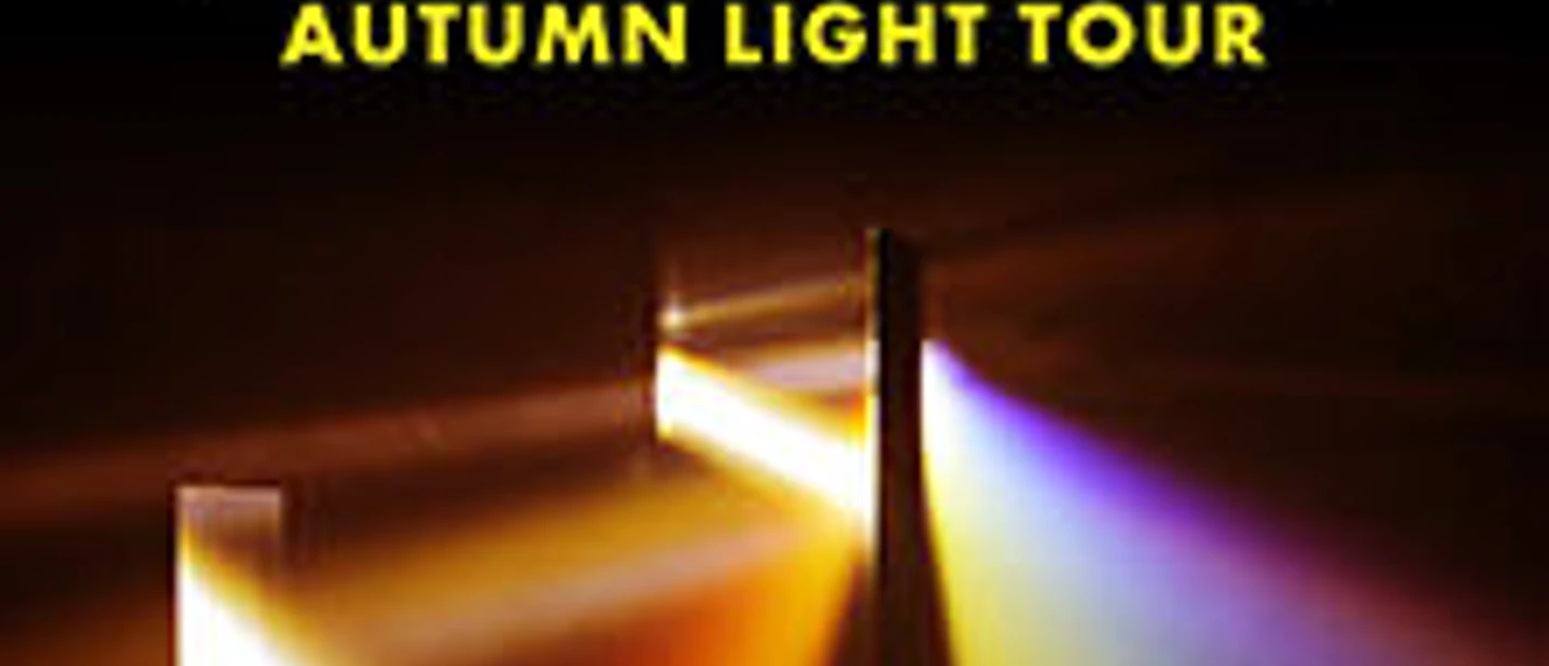 Weißer Schriftzug The Fray über gelbem Tourtitel vor zwei farbigen Lichtstrahlen.