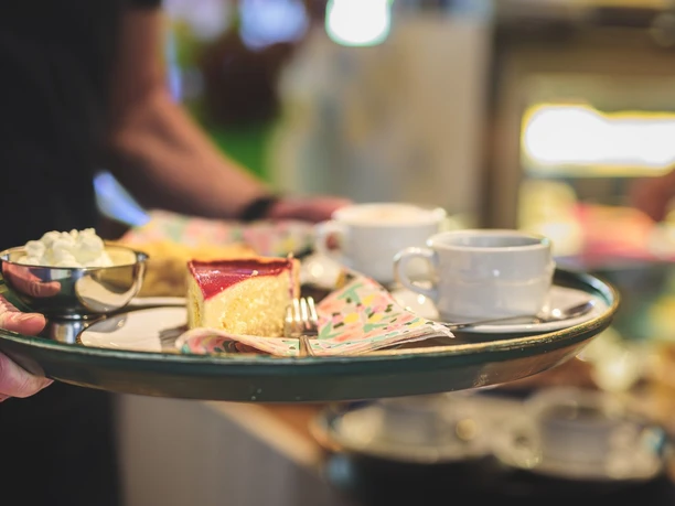 Landcafé_Armstorf.jpg Kuchen, Sahne und zwei Kaffees befinden sich per Tablett auf dem Weg zu den Gästen im Landcafé Armstorf.