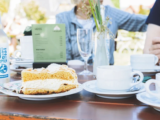 Landcafé_Armstorf.jpg Ein Tisch im Landcafé Armstorf gedeckt mit Kuchen, Kaffee, Wasser und Blumen