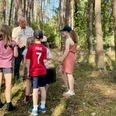 wald-detektive-bispingen (2).jpg Kinder stehen im Wald und lauschen aufmerksam den Erklärungen eines Naturführers.