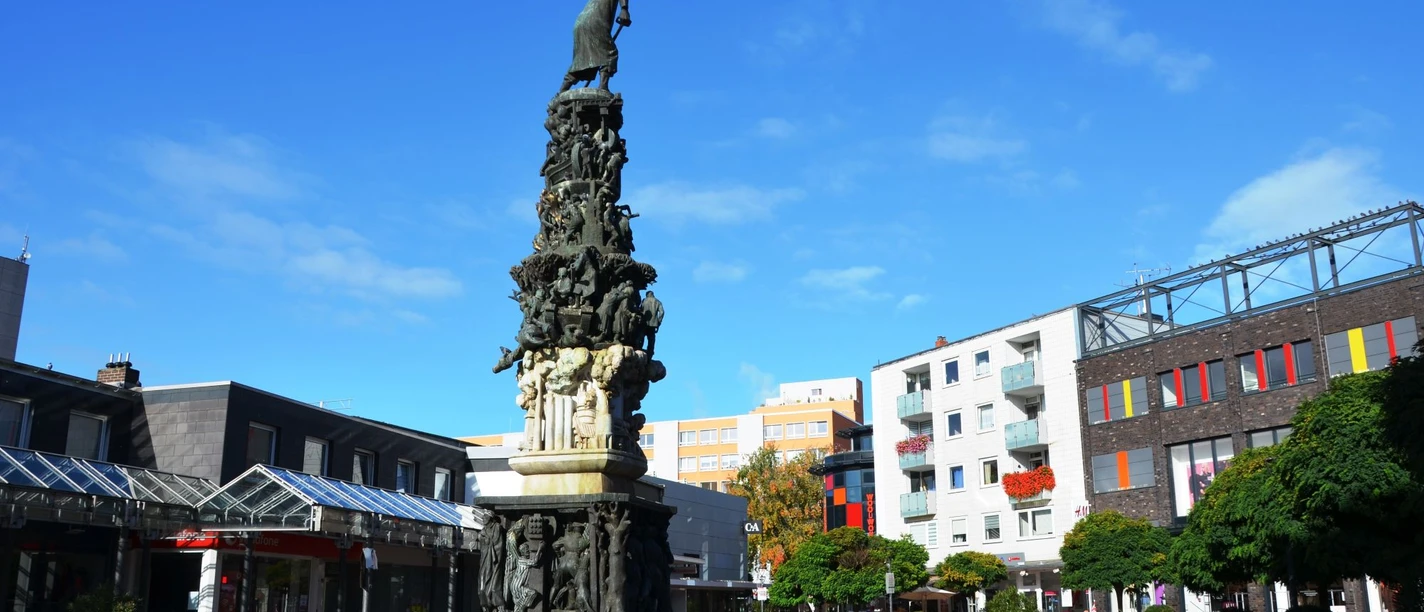 Monument_zur_Stadtgeschichte_Salzgitter_HD_16zu9.JPG Hohes Stadtmonument Salzgitter mit vielen Figuren auf einem städtischen Platz.