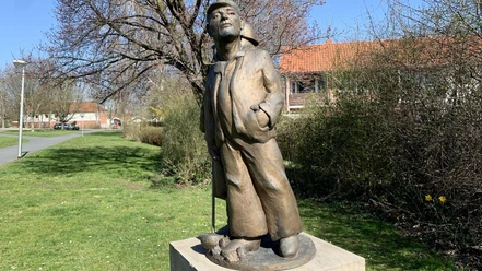 Skulpturenpfad_Gebhardshagen_HD_16zu9.jpg Bronzestatue eines Arbeiters mit Mütze im Park am Skulpturenweg Gebhardshagen.