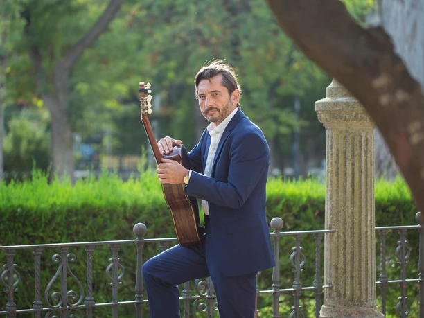 Jose Maria Gallardo del Rey-(c) Juanlu Galán.jpg Jose Maria Gallardo del Rey mit Gitarre in grünem Park vor Strauch