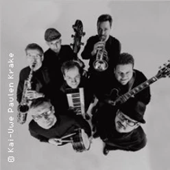 Sieben Musiker von oben mit Saxofon, Trompete, Gitarre, Bass und Keyboard in Schwarzweiß