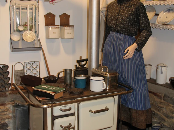 Küchenzauber von anno dazumal Sie sehen eine typische Küchenszene von anno dazumal, mit einer Frau an dem alten Holz-Herd.