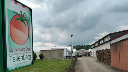 Direktvermarkter_Fellenberg_HD_16zu9.jpg Schild mit Tomate für Gemüse und Obst Fellenberg an einer Einfahrt zu Gewächshäusern.