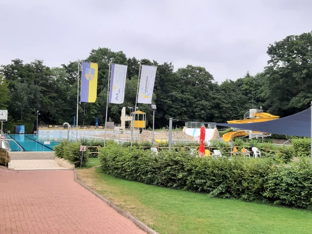 Sport- und Abenteuerbecken mit Kinderbereich 1 Außenbecken mit Sportbahnen, Abenteuerbecken mit gelber Rutsche und Kinderbereich im Freizeitbad.