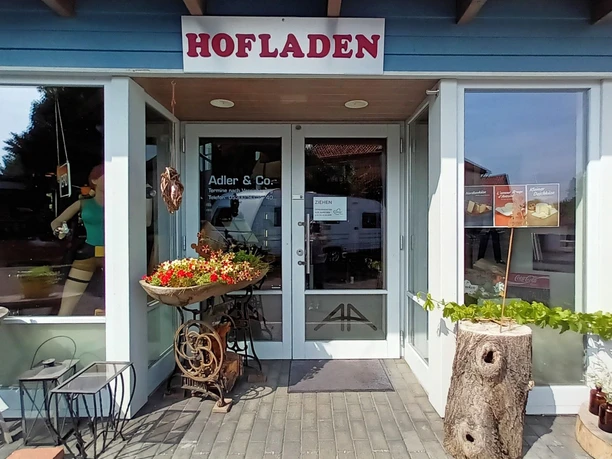 Herzensgut_Hofladen_Üfingen_HD_16zu9.jpg Eingangsbereich des Hofladens Herzensgut mit dekoriertem Vorplatz und großen Schaufenstern.