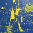 Ein abstraktes Kunstwerk mit gelber Farbe auf blauem Hintergrund, dynamisch verteilt.