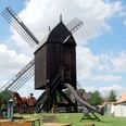 Bockwindmuehle_Salder_HD_16zu9.jpg Historische Osterlinder Bockwindmühle aus Holz an einem sonnigen Tag unter blauem Himmel.