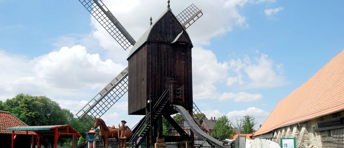 Bockwindmuehle_Salder_HD_16zu9.jpg Historische Osterlinder Bockwindmühle aus Holz an einem sonnigen Tag unter blauem Himmel.