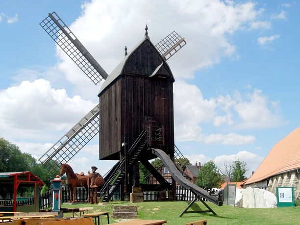 Bockwindmuehle_Salder_HD_16zu9.jpg Historische Osterlinder Bockwindmühle aus Holz an einem sonnigen Tag unter blauem Himmel.