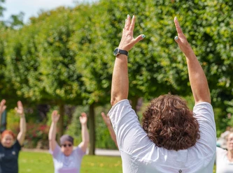 Yoga im Wohlfühlgarten Personen machen Yoga im Grünen.