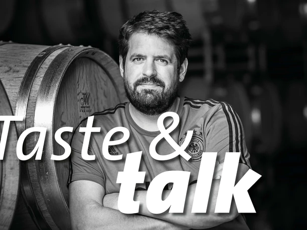 Taste & Talk im Kölner Weinkeller x Markus Schneider Mann vor Weinfässern in Schwarzweiß mit Schriftzug Taste & talk