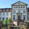 Schloss Ringelheim_HD_16zu9.JPG Frontansicht des weißen Schlosses Ringelheim mit Steintreppe und zentralem Rundbogenportal.