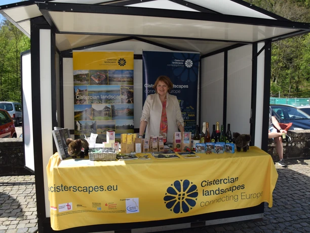 Altenberger Klostermarkt 2025 Frau am Marktstand mit Produkten und Bannern "Cistercian landscapes" beim Klostermarkt Altenberg.