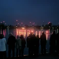 Fackelschwimmen_Salzgittersee_HD_16zu9.jpg Publikum am Ufer beobachtet leuchtende Fackelschwimmer am Ostersonntag im Salzgittersee.