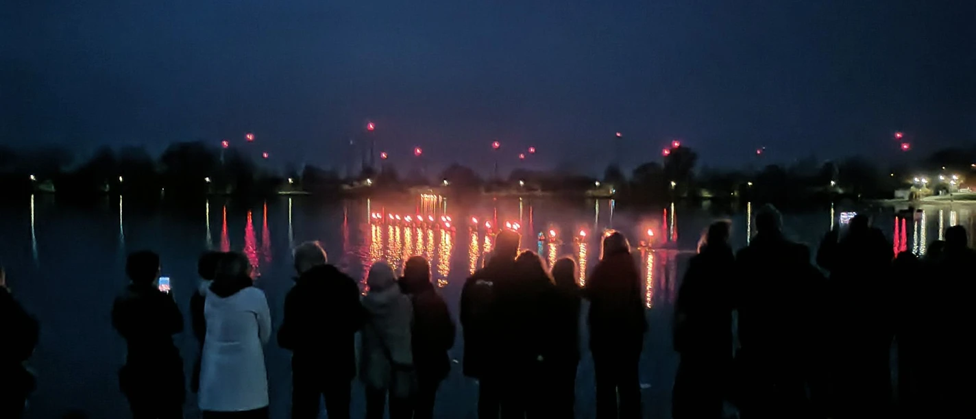 Fackelschwimmen_Salzgittersee_HD_16zu9.jpg Publikum am Ufer beobachtet leuchtende Fackelschwimmer am Ostersonntag im Salzgittersee.