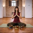 klangschalen-meditation-(4).jpg Eine Frau sitzt in Meditationshaltung auf dem Boden